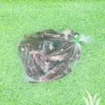 Plastic zak met bevroren vleesvleugels op groene ondergrond