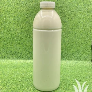 Plastic fles met witte vloeistof op groene ondergrond